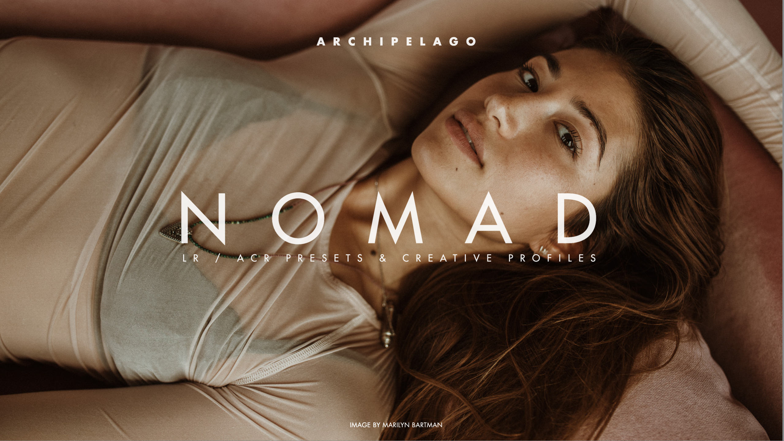 A beautiful woman lays on the floor and looks at the camera, an ad for nomad lightroom presets by archipelago presets.