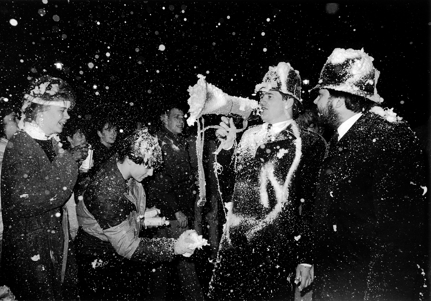British bobbies in a shaving cream fight on new year's even in 1985 in london, england; photo taken by photographer jill waterman.