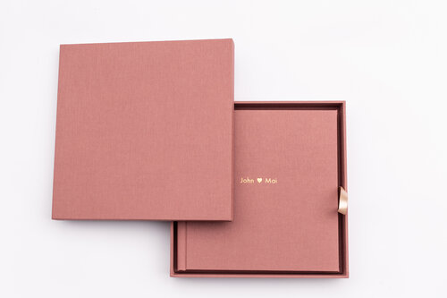 Pink artbook photography album on top of a clean white background.