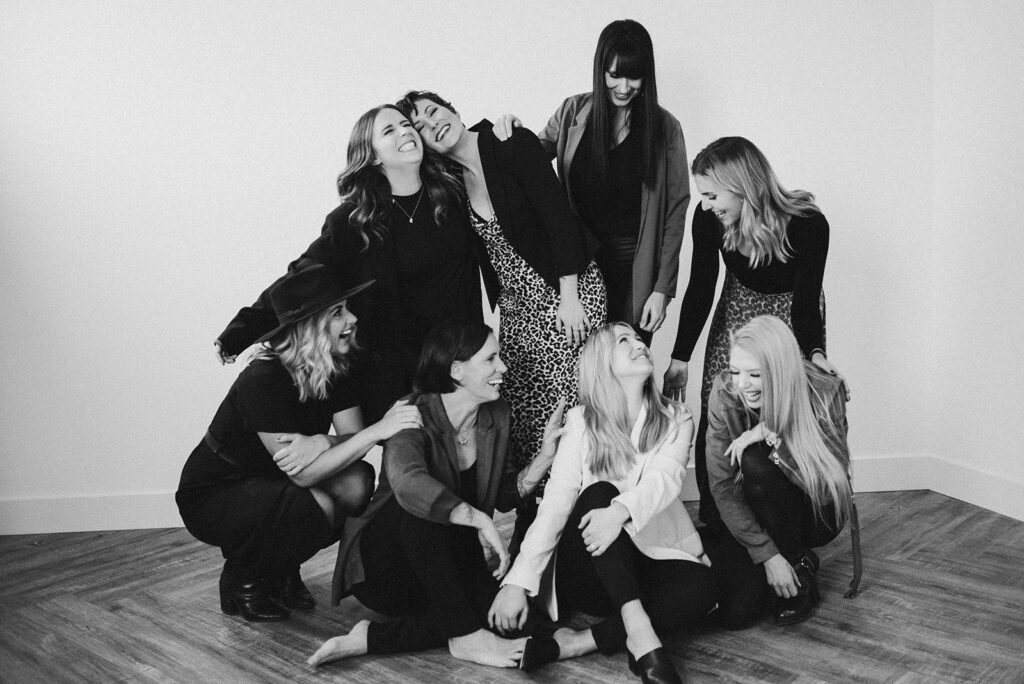 The women of a marketing agency for photographers and creative entrepreneurs called Meet Pepper smile and laugh with each other for brand photos in Kamloops. 