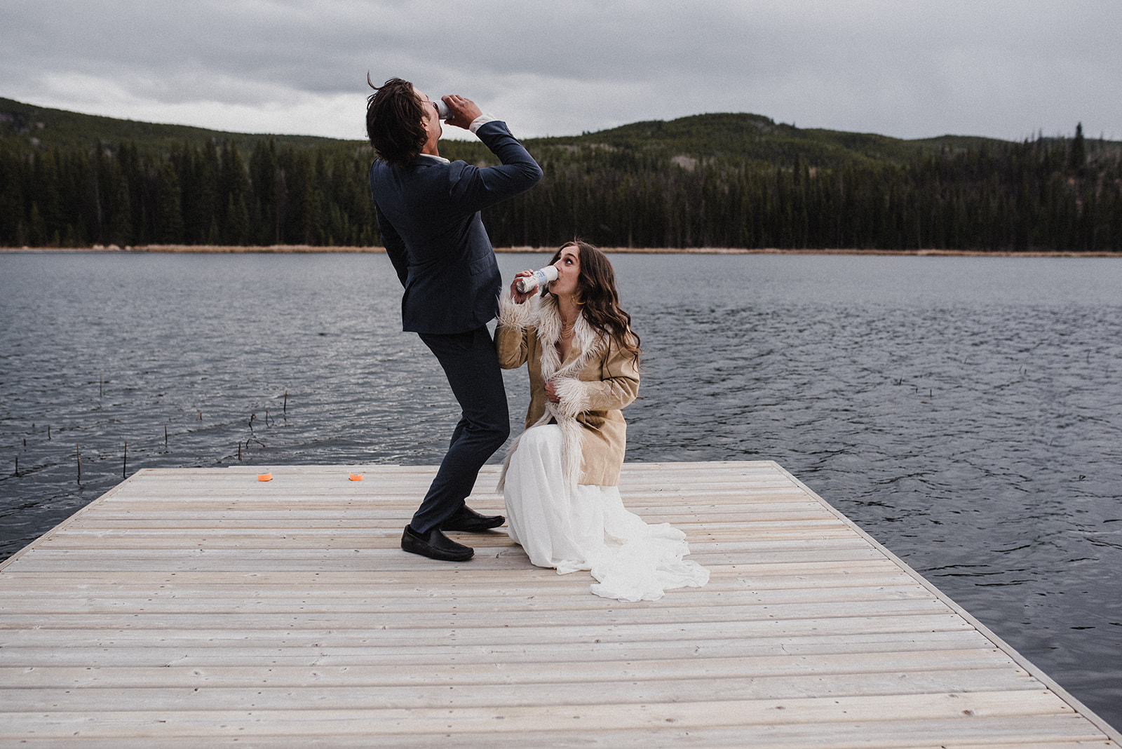 bride and groom on a dock overlooking a lake cheers and chug their website success thanks to Pepper SEO services. 