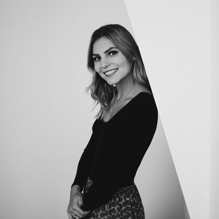Kayleigh Zinger, writer and content creator at Meet Pepper, leaning against a wall and smiling.