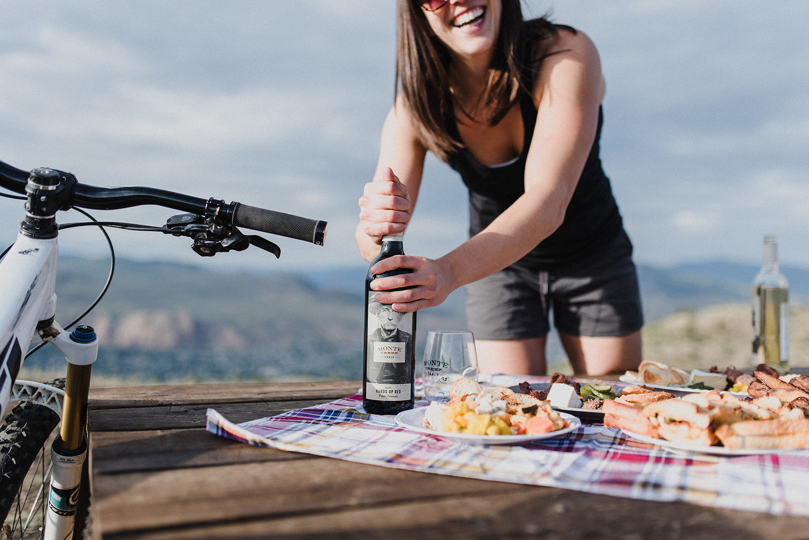 woman cracks a bottle of wine and prepares to picnic to celebrate the recent branding services she's received from meet pepper in kamloops