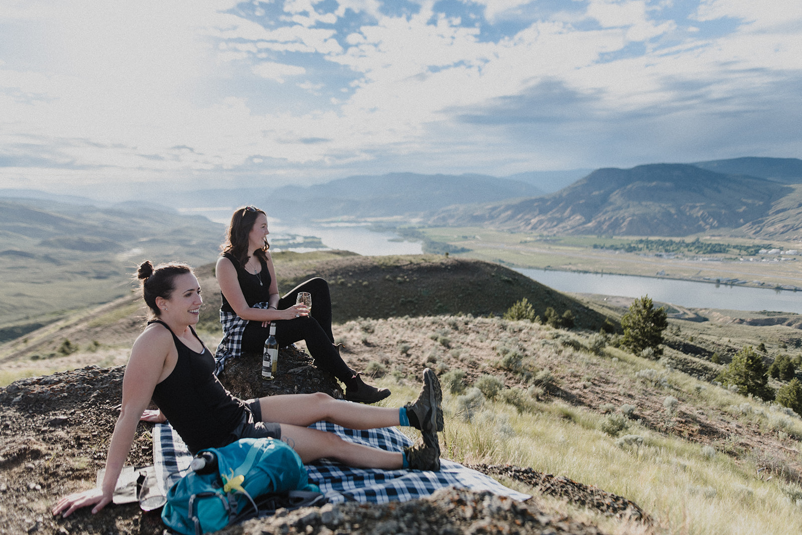 two white women site at the top of a hill overlooking kamloops in this yka local branding shoot for Monte creek winery by meet pepper