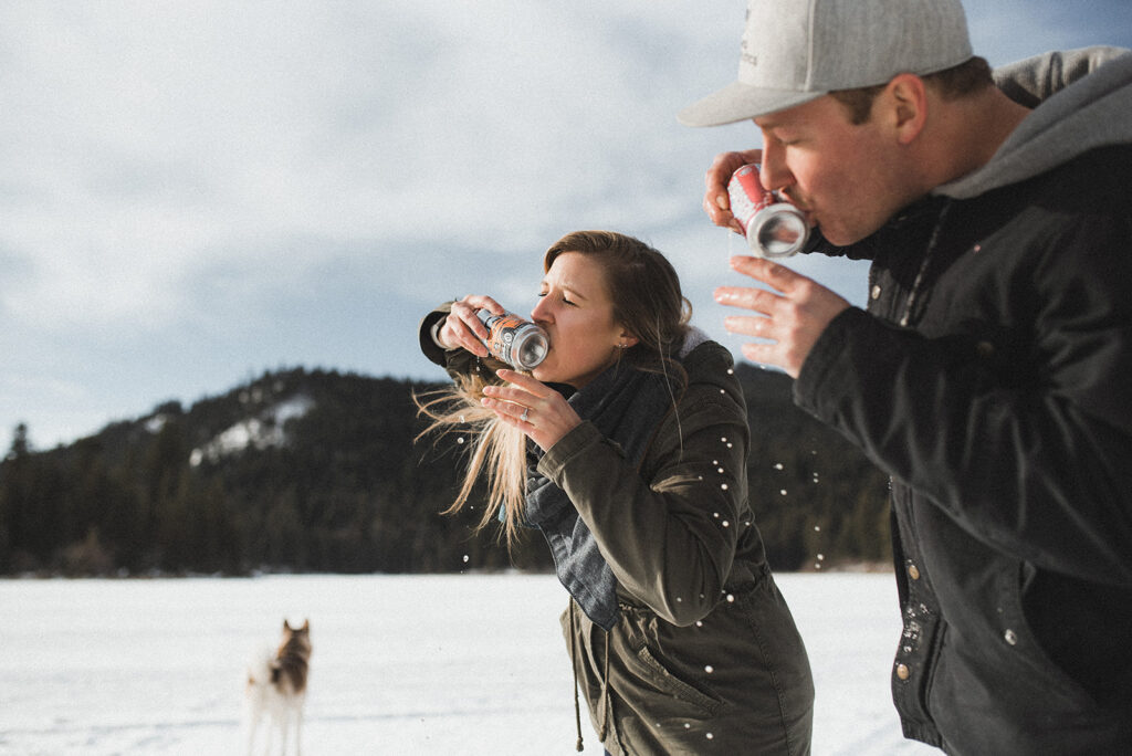 a couple shotgunning beers on a frozen lake in golden celebrating the success of their pinterest account thanks to meet pepper pinterest services 