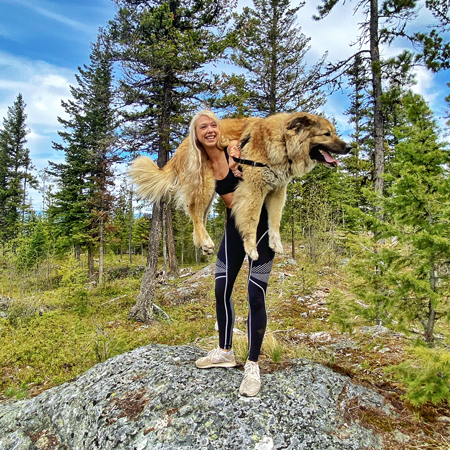 paris, content creator at the marketing agency in kamloops Pepper, holds her huge dog on her shoulders during a hike.