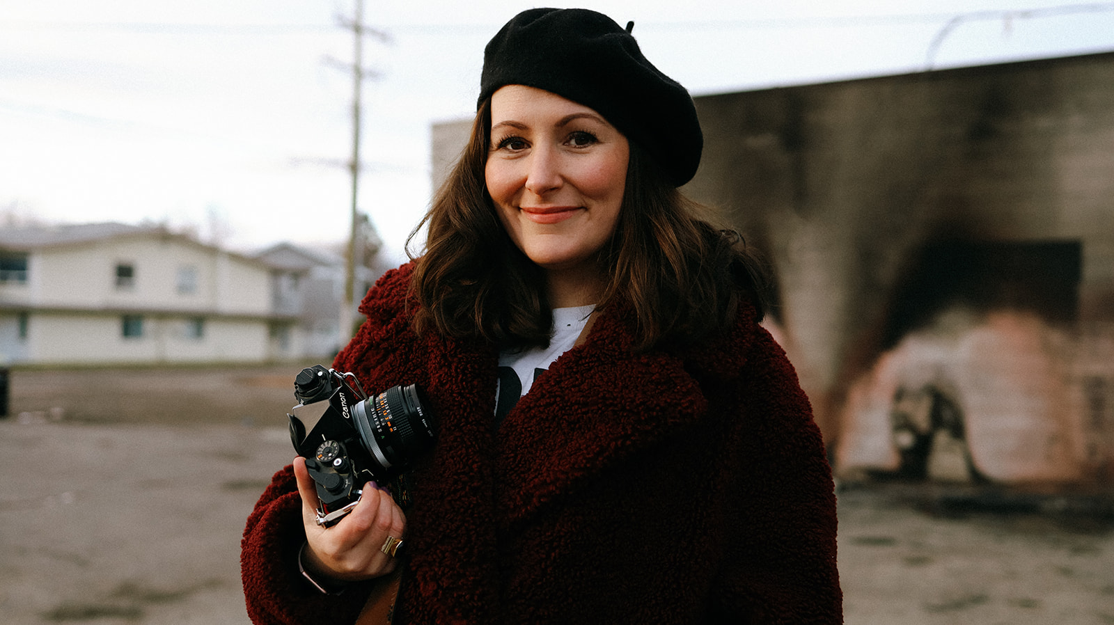 Stacey Owen, founder of Meet Pepper which offers marketing and blog outsourcing for photographers, wearing a beret and holding a camera. 