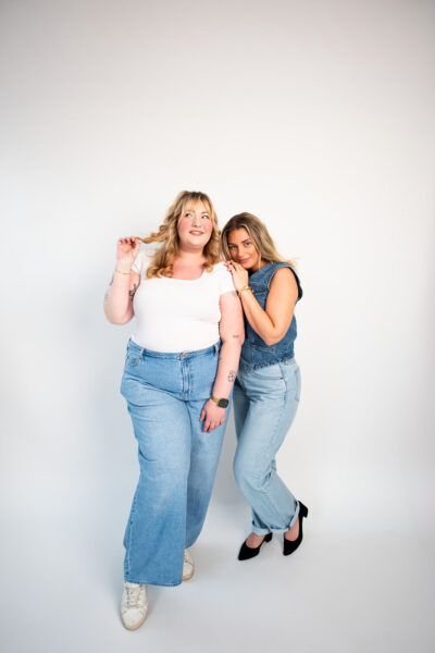 Two women in denim outfits walking toward the camera in a studio, capturing casual lifestyle imagery for brand marketing and social media content.