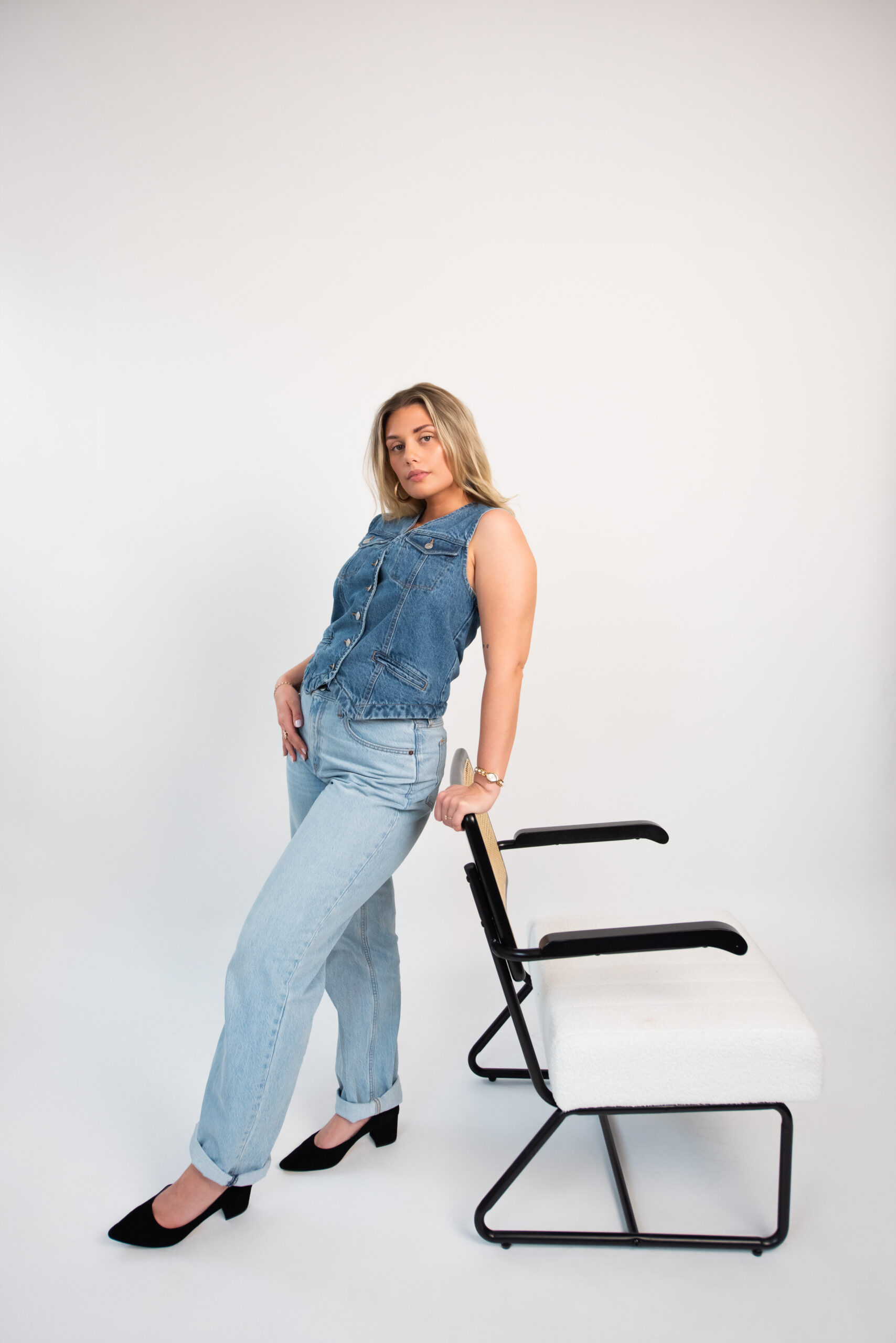 Pepper team member posing beside modern chair in studio during branding photoshoot for marketing agency content