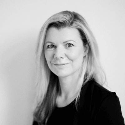 Black and white professional portrait of a woman wearing a blazer against a clean background for business branding.