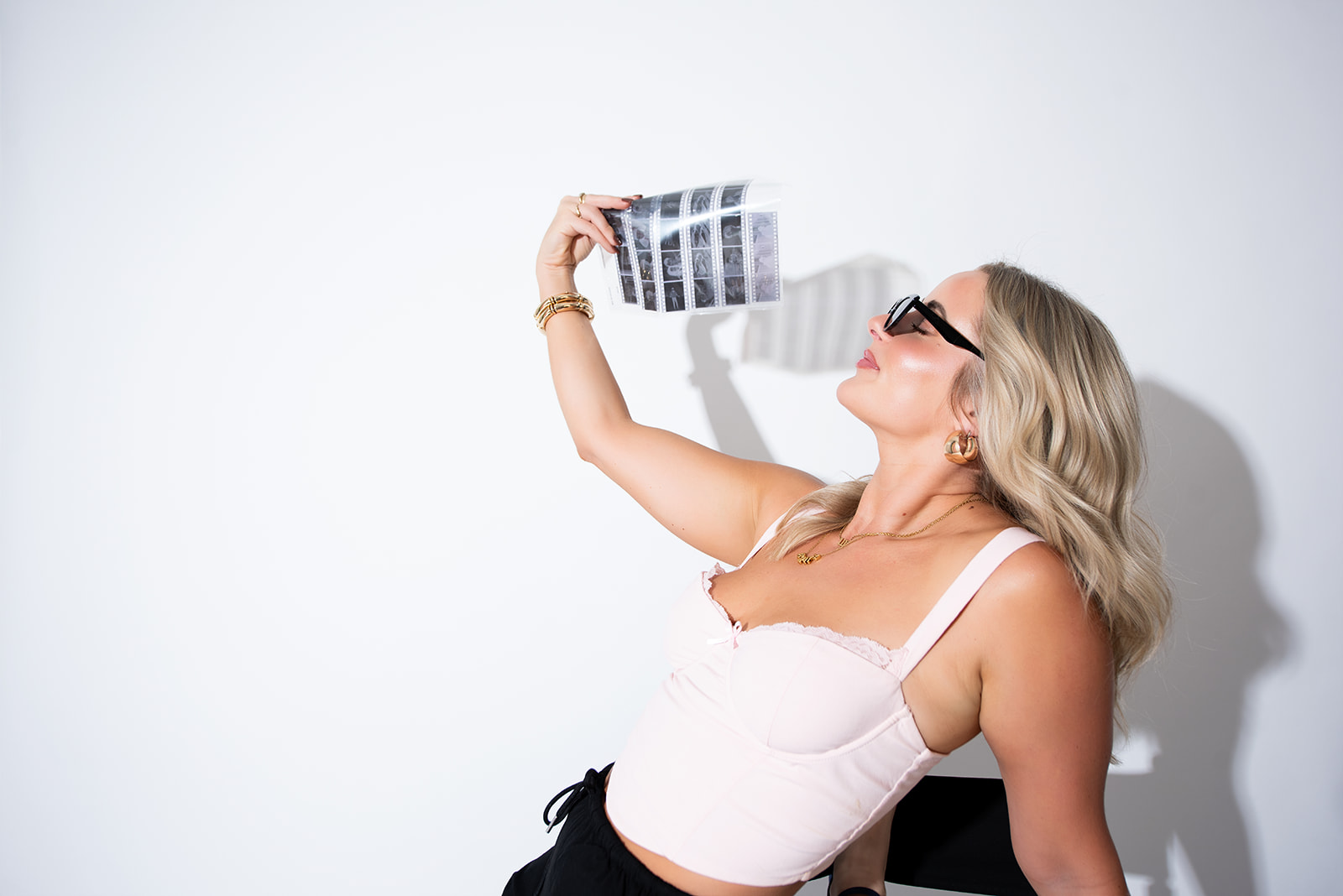 Pepper marketing team member holding photo prints during studio content shoot, representing brand photography and creative marketing services in Kamloops