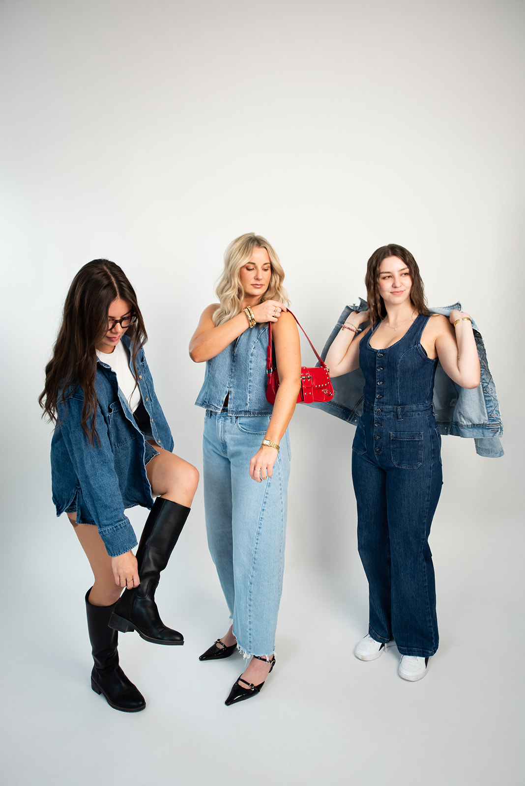 Three women modeling denim outfits and accessories in a studio during a fashion-focused branding photoshoot for lifestyle and marketing imagery.