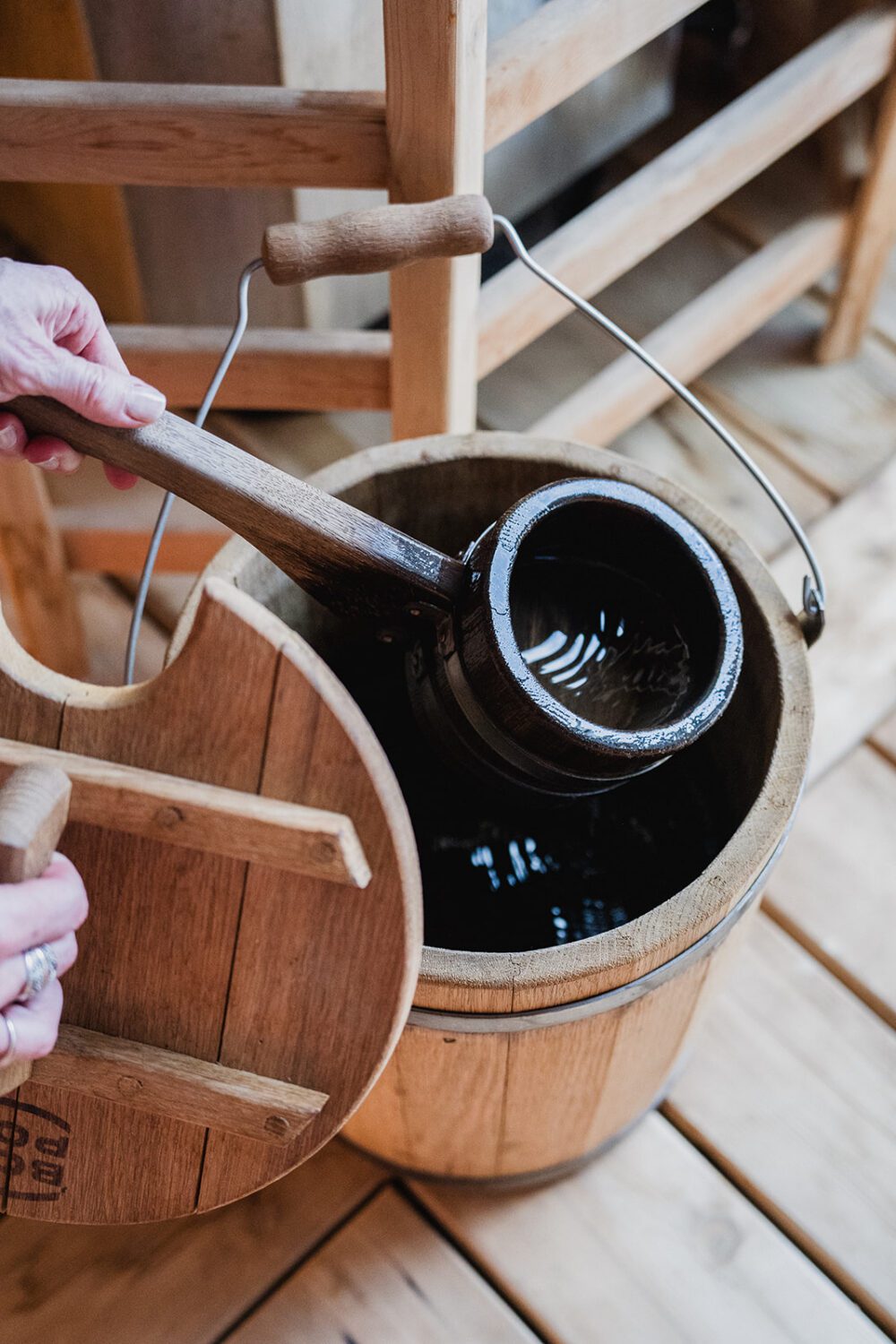 Wooden sauna bucket and ladle filled with water on the deck at The Spot.