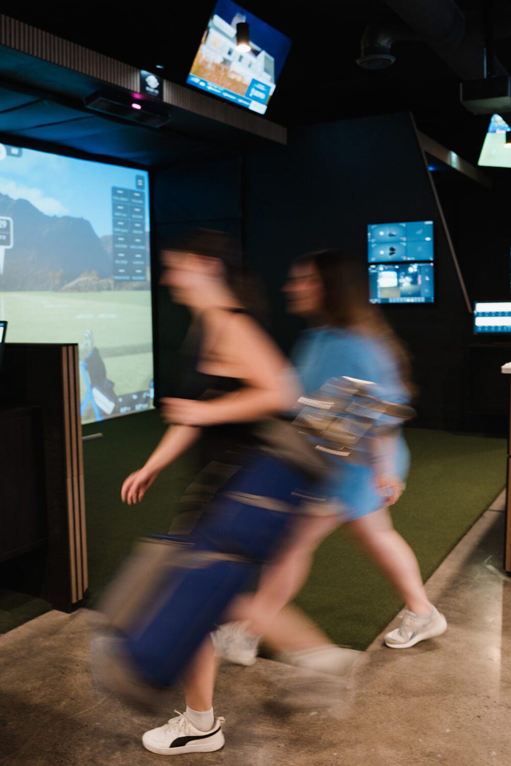 Friends playing golf together in a simulator at Kamloops Virtual Golf.
