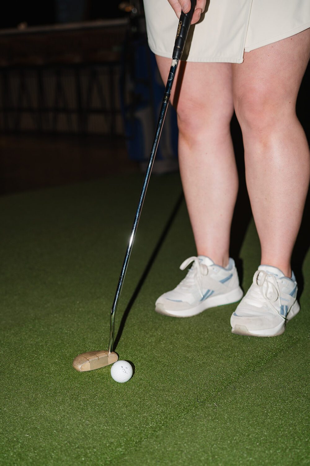 Close-up of a golfer taking a swing inside a Kamloops Virtual Golf simulator.