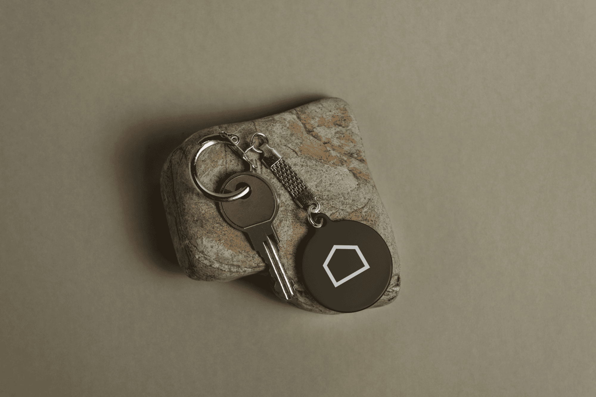 House key with a round Madok Developments keychain featuring the geometric brand icon created by Pepper.